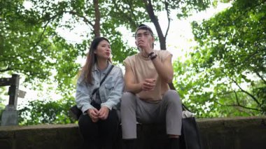 Tayvanlı genç bir çift, yirmili yaşlarda bir bankta oturuyor ve Taipei 'deki Xinyi Bölgesi' nde bir dağın tepesinde sohbet ediyorlar. Adam kolsuz bir bluz giyiyor..