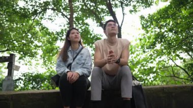 Tayvanlı genç bir çift, yirmili yaşlarda bir bankta oturuyor ve Taipei 'deki Xinyi Bölgesi' nde bir dağın tepesinde sohbet ediyorlar. Adam kolsuz bir bluz giyiyor..