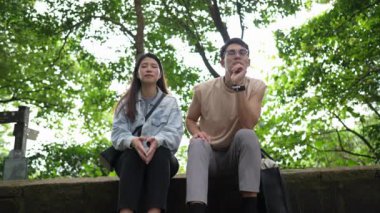 Tayvanlı genç bir çift, yirmili yaşlarda bir bankta oturuyor ve Taipei 'deki Xinyi Bölgesi' nde bir dağın tepesinde sohbet ediyorlar. Adam kolsuz bir bluz giyiyor..