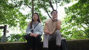 Tayvanlı genç bir çift, yirmili yaşlarda bir bankta oturuyor ve Taipei 'deki Xinyi Bölgesi' nde bir dağın tepesinde sohbet ediyorlar. Adam kolsuz bir bluz giyiyor..