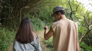 Tayvanlı genç bir çift, yirmili yaşlarda Taipei 'nin Xinyi bölgesinde küçük bir patikada yürüyor ve konuşuyor. Adam kolsuz bir bluz giyiyor ve kadın kot pantolon giyiyor.