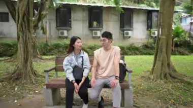 Tayvanlı genç bir çift yirmili yaşlarda Taipei 'nin Xinyi İlçesi' ndeki bir parkta oturuyor ve konuşuyor. Adam kolsuz bir bluz giyiyor ve kadın kot pantolon giyiyor.