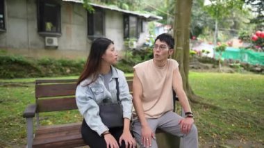 Tayvanlı genç bir çift yirmili yaşlarda Taipei 'nin Xinyi İlçesi' ndeki bir parkta oturuyor ve konuşuyor. Adam kolsuz bir bluz giyiyor ve kadın kot pantolon giyiyor.