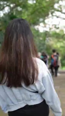 Tayvanlı genç bir çiftin Taipei 'nin Xinyi İlçesi' ndeki küçük bir patikada yürüdüğü ve konuştuğu dikey bir video. Adam kolsuz bir bluz giyiyor ve kadın kot ceket giyiyor..