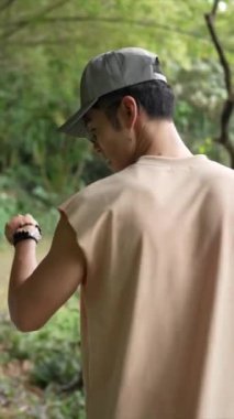 Tayvanlı genç bir çiftin Taipei 'nin Xinyi İlçesi' ndeki küçük bir patikada yürüdüğü ve konuştuğu dikey bir video. Adam kolsuz bir bluz giyiyor ve kadın kot ceket giyiyor..