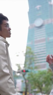 Tayvanlı genç bir çiftin yirmili yaşlarda Taipei 101 ile yan yana durduğu dikey bir video. Taipei şehrinin Xinyi ilçesinde bir bahar öğleden sonrası..