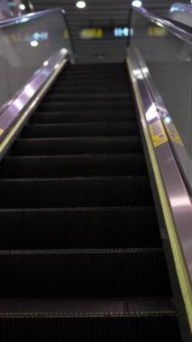 Wanhua Bölgesi, Taipei şehrindeki bir metro istasyonunda yürüyen merdivene tırmanan insanların dikey yavaş çekim videosu..