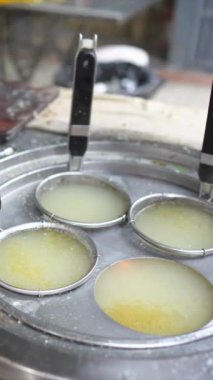 Taipei şehrinin Wanhua semtindeki bir alışveriş caddesinde yerel bir restoranın mutfağında lezzetli görünümlü sarı bir çorbanın ısındığı bir sahneyi gösteren dikey yavaş çekim videosu..