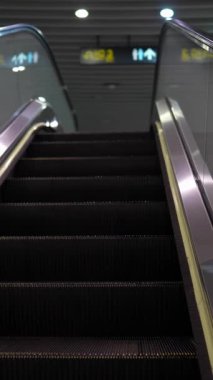 Wanhua Bölgesi, Taipei şehrindeki bir metro istasyonunda yürüyen merdivene tırmanan insanların dikey yavaş çekim videosu..