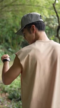 Taipei 'nin Xinyi İlçesi' nde küçük bir patika boyunca yürüyen ve konuşan 20 'li yaşlarda genç bir Tayvanlı çiftin dikey yavaş çekim videosu. Adam kolsuz bir bluz giyiyor.