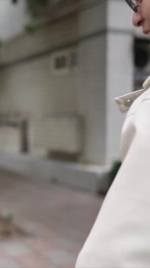 Taipei 'nin Xinyi İlçesi sokaklarında yirmili yaşlarda genç bir Tayvanlı çiftin bahar öğleden sonra yürüdüğü dikey ağır çekim bir video. Adam kapüşonlu giyiyor.