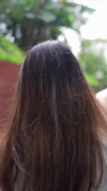 Taipei 'nin Xinyi İlçesi sokaklarında yirmili yaşlarda genç bir Tayvanlı çiftin bahar öğleden sonra yürüdüğü dikey ağır çekim bir video. Adam kolsuz bir bluz giyiyor.