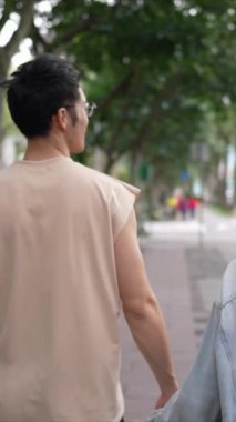 Taipei 'nin Xinyi İlçesi sokaklarında yirmili yaşlarda genç bir Tayvanlı çiftin bahar öğleden sonra yürüdüğü dikey ağır çekim bir video. Adam kolsuz bir bluz giyiyor.