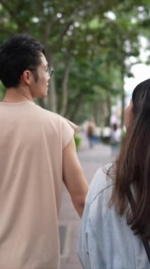 Taipei 'nin Xinyi İlçesi sokaklarında yirmili yaşlarda genç bir Tayvanlı çiftin bahar öğleden sonra yürüdüğü dikey ağır çekim bir video. Adam kolsuz bir bluz giyiyor.