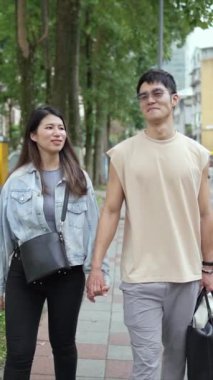 Taipei 'nin Xinyi İlçesi sokaklarında yirmili yaşlarda genç bir Tayvanlı çiftin bahar öğleden sonra yürüdüğü dikey ağır çekim bir video. Adam kolsuz bir bluz giyiyor.