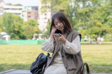 Yazın başlarında, genç bir Çinli değişim öğrencisi Hamamatsucho, Minato, Tokyo yakınlarındaki bir parkta bir bankta oturuyor ve gün içinde akıllı telefon kullanıyor..