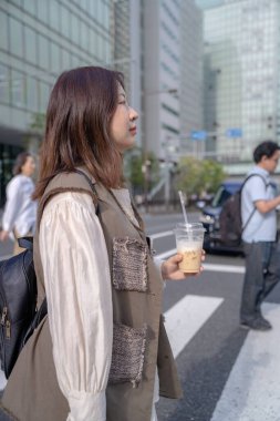 Yazın başlarında, genç bir Çinli değişim öğrencisi, 20 'li yaşlarda, Tokyo, Minato' daki yoğun Hamamatsucho İstasyonu civarında dolanıyor, elinde plastik bir bardakta buzlu bir sütlü kahve tutuyor..