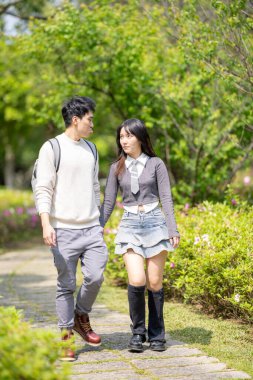 Mart ayında, ortancaların açmasıyla yirmili yaşlarda Tayvanlı bir kadın ve Hong Kong 'lu bir adam birlikte Tayvan' ın Taipei bölgesindeki Zhongzheng bölgesinde bir parkta yürüyüş yapıyorlar..