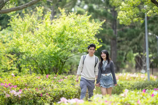 stock image In March, with hydrangeas blooming, a Taiwanese woman in her twenties and a Hong Kong man are enjoying a walk together in a park in Zhongzheng District, Taipei City, Taiwan.