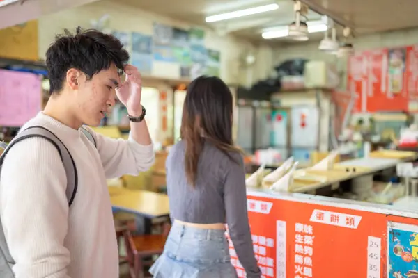 stock image March, near the Zhongshan Memorial Hall in Zhongzheng District, Taipei City, Taiwan, Taiwanese woman in her twenties and a Hong Kong man are enjoying a meal of soy milk and radish cake at local shop.