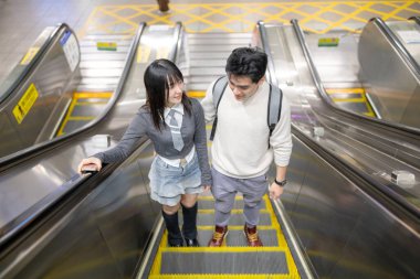 Mart ayında yirmili yaşlarda Tayvanlı bir kadın ve Hong Kong 'lu bir adam Taipei, Tayvan' daki Zhongzheng Bölgesi 'ndeki bir istasyonda yürüyen merdivene biniyorlar..