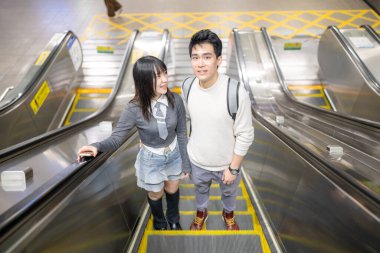 Mart ayında yirmili yaşlarda Tayvanlı bir kadın ve Hong Kong 'lu bir adam Taipei, Tayvan' daki Zhongzheng Bölgesi 'ndeki bir istasyonda yürüyen merdivene biniyorlar..