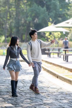 Mart ayında yirmili yaşlarda Tayvanlı bir kadın ve Hong Kong 'lu bir adam Zhongzheng Bölgesi, Tayvan' daki Zhongshan Memorial Hall yakınlarında bir parkta yürüyorlar..