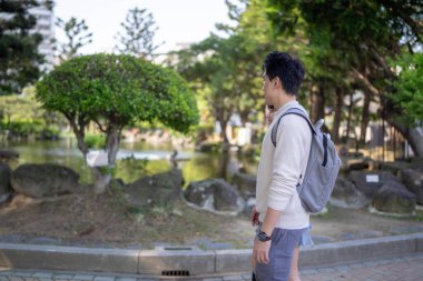 In March, a Taiwanese woman in her twenties and a Hong Kong man are walking in a park near Zhongshan Memorial Hall in Zhongzheng District, Taipei City, Taiwan. clipart