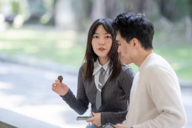 Mart ayında yirmili yaşlarda Tayvanlı bir kadın ve Hong Kong 'lu bir adam Tayvan' ın Taipei şehrindeki Zhongzheng bölgesinde bir parkta mola verip abur cubur yiyip su içiyorlar..