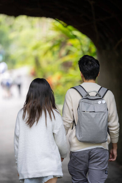 In March, a Taiwanese woman in her twenties and a Hong Kong man are walking in a lush botanical garden in Zhongzheng District, Taipei City, Taiwan.