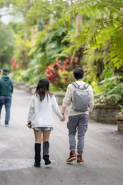 stock image In March, a Taiwanese woman in her twenties and a Hong Kong man are walking in a lush botanical garden in Zhongzheng District, Taipei City, Taiwan.