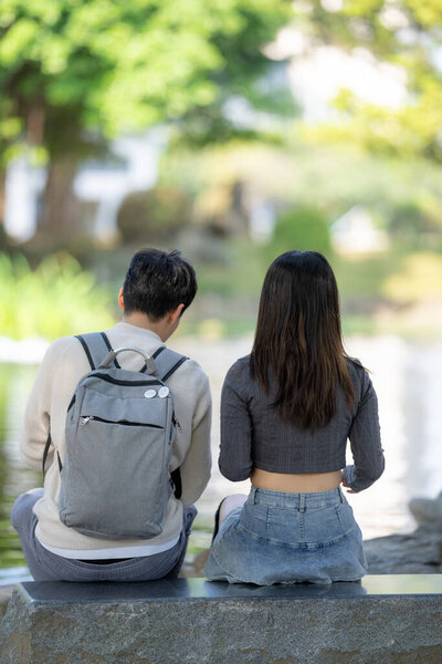 In March, a Taiwanese woman in her twenties and a Hong Kong man are feeding koi fish in a park in Zhongzheng District, Taipei City, Taiwan.