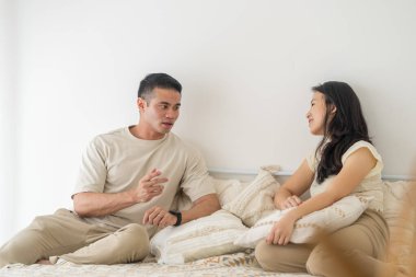 Selangor, Malezya, yirmili yaşlarda Çinli Malezyalı bir kadın ve otuzlu yaşlarda Hintli Malezyalı bir adamdan oluşan çift, Asya 'dan esinlenilmiş mobilyalarla şık bir odada dinleniyor ve yatakta konuşuyorlar..