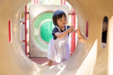 Malezya 'daki Kuala Lumpur Şehir Merkezi' ndeki KLCC Parkı 'nda çocuk parkında oynayan bir yaşındaki Malezyalı kız..