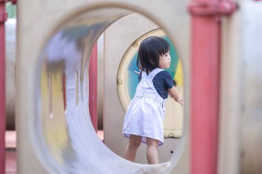 Malezya 'daki Kuala Lumpur Şehir Merkezi' ndeki KLCC Parkı 'nda çocuk parkında oynayan bir yaşındaki Malezyalı kız..