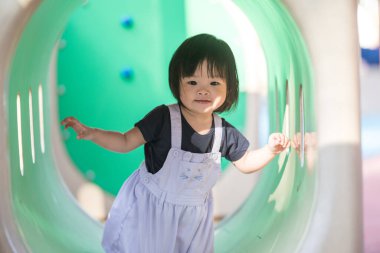 Malezya 'daki Kuala Lumpur Şehir Merkezi' ndeki KLCC Parkı 'nda çocuk parkında oynayan bir yaşındaki Malezyalı kız..