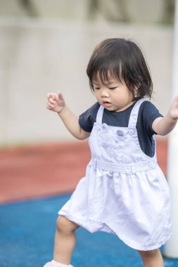 Malezya 'daki Kuala Lumpur Şehir Merkezi' ndeki KLCC Parkı 'nda çocuk parkında oynayan bir yaşındaki Malezyalı kız..