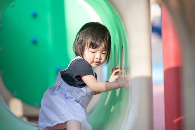 Malezya 'daki Kuala Lumpur Şehir Merkezi' ndeki KLCC Parkı 'nda çocuk parkında oynayan bir yaşındaki Malezyalı kız..