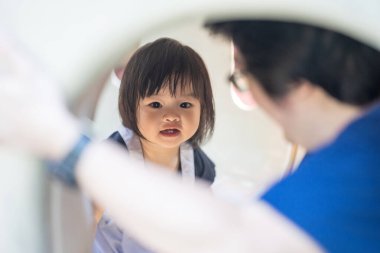 Malezya 'daki Kuala Lumpur Şehir Merkezi' ndeki KLCC Parkı 'nda 30' lu yaşlardaki babasıyla çocuk parkı ekipmanlarında oynayan bir Çinli kız..