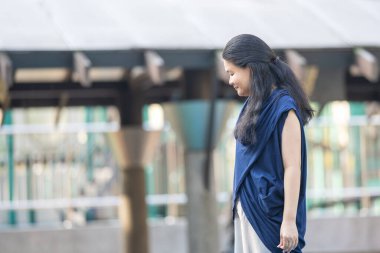 Otuz yaşlarında Çinli bir anne Malezya 'nın Kuala Lumpur Şehir Merkezi' ndeki KLCC Parkı 'nda çocuğunun oyun parkında oynamasını izliyor..