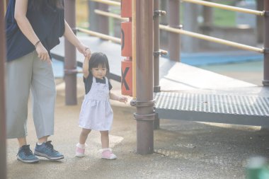 Malezya 'daki Kuala Lumpur Şehir Merkezi' ndeki KLCC Parkı 'nda 30' lu yaşlarında annesiyle birlikte çocuk parkında oynayan bir Çinli kız çocuğu..