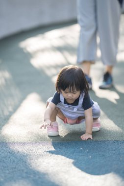 Malezya 'daki Kuala Lumpur Şehir Merkezi' ndeki KLCC Parkı 'nda 30' lu yaşlarında annesiyle birlikte çocuk parkında oynayan bir Çinli kız çocuğu..