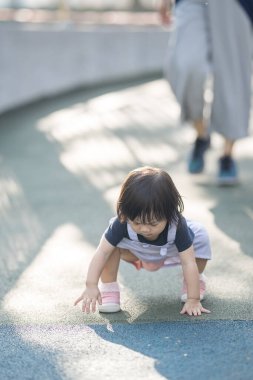 Malezya 'daki Kuala Lumpur Şehir Merkezi' ndeki KLCC Parkı 'nda 30' lu yaşlarında annesiyle birlikte çocuk parkında oynayan bir Çinli kız çocuğu..