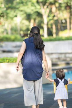 Malezya 'daki Kuala Lumpur Şehir Merkezi' ndeki KLCC Parkı 'nda 30' lu yaşlarında annesiyle birlikte çocuk parkında oynayan bir Çinli kız çocuğu..