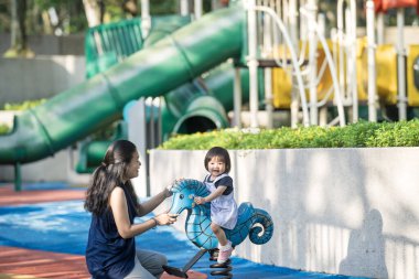 Malezya 'daki Kuala Lumpur Şehir Merkezi' ndeki KLCC Parkı 'nda 30' lu yaşlarında annesiyle birlikte çocuk parkında oynayan bir Çinli kız çocuğu..