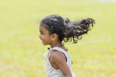 Malezya 'nın Kuala Lumpur kentindeki Merdeka Meydanı' nda beyaz elbiseli, neşeli bir şekilde koşan beş yaşındaki Hintli kız..