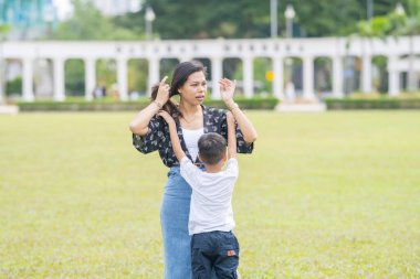 Malezya 'nın Kuala Lumpur kentindeki Merdeka Meydanı' nda, 7 yaşındaki oğlunu kucağında tutan 30 küsur Hintli Malezyalı anne neşeyle oyun oynuyor..