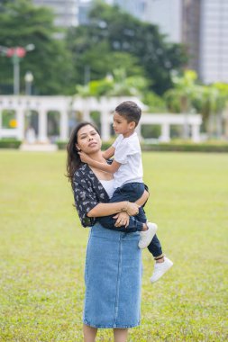 Malezya 'nın Kuala Lumpur kentindeki Merdeka Meydanı' nda, 7 yaşındaki oğlunu kucağında tutan 30 küsur Hintli Malezyalı anne neşeyle oyun oynuyor..