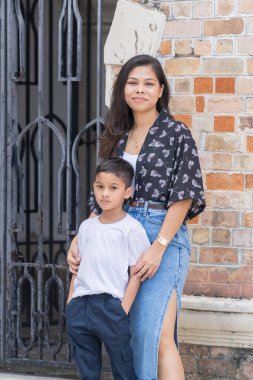 30 yaşlarında Hintli bir Malezyalı anne ve 7 yaşındaki oğlu sıcak bir günde Malezya 'nın başkenti Kuala Lumpur' da batı tarzı bir tuğla binanın önünde neşeyle vakit geçiriyorlar..