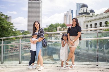 7 yaşındaki oğulları ve 5 yaşındaki kızlarıyla birlikte 30 küsur Hintli anne, Malezya 'nın başkenti Kuala Lumpur' da bir köprüde neşeyle vakit geçiriyorlar..